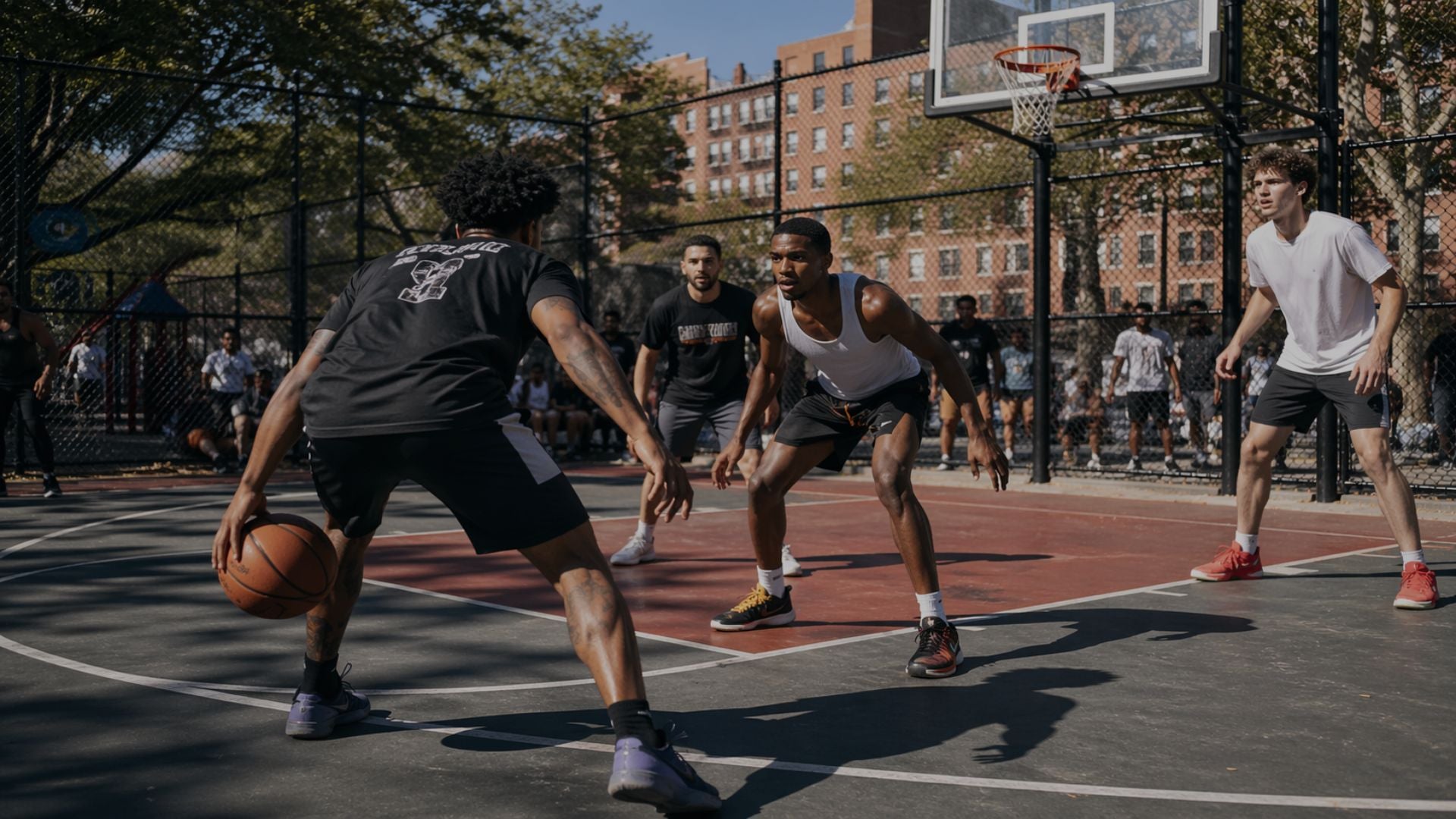 Basketball game in progress on an outdoor court with players and a hoop.
