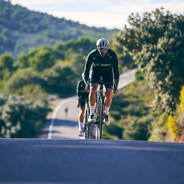 Cyclist on a mountain road with scenic greenery
